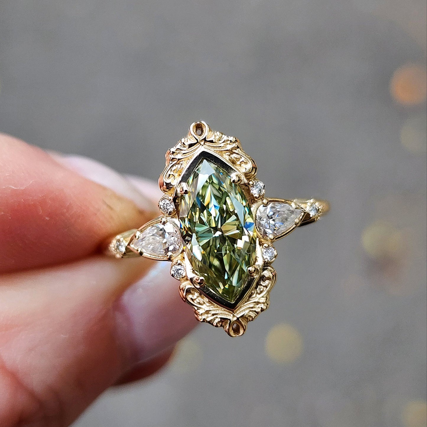 Fairy green marquise moissanite engagement ring Odette with gold scroll side band and diamond accents 14k yellow gold vintage inspired artisan fine jewelry made in portland oregon