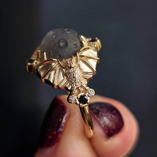 Keeper of the Moon ring by SwankMetalsmithing with hand carved gray moonstone moon and gold vampire bats