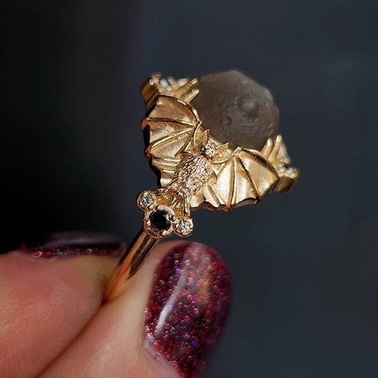 Keeper of the Moon ring by SwankMetalsmithing with hand carved gray moonstone moon and gold vampire bats