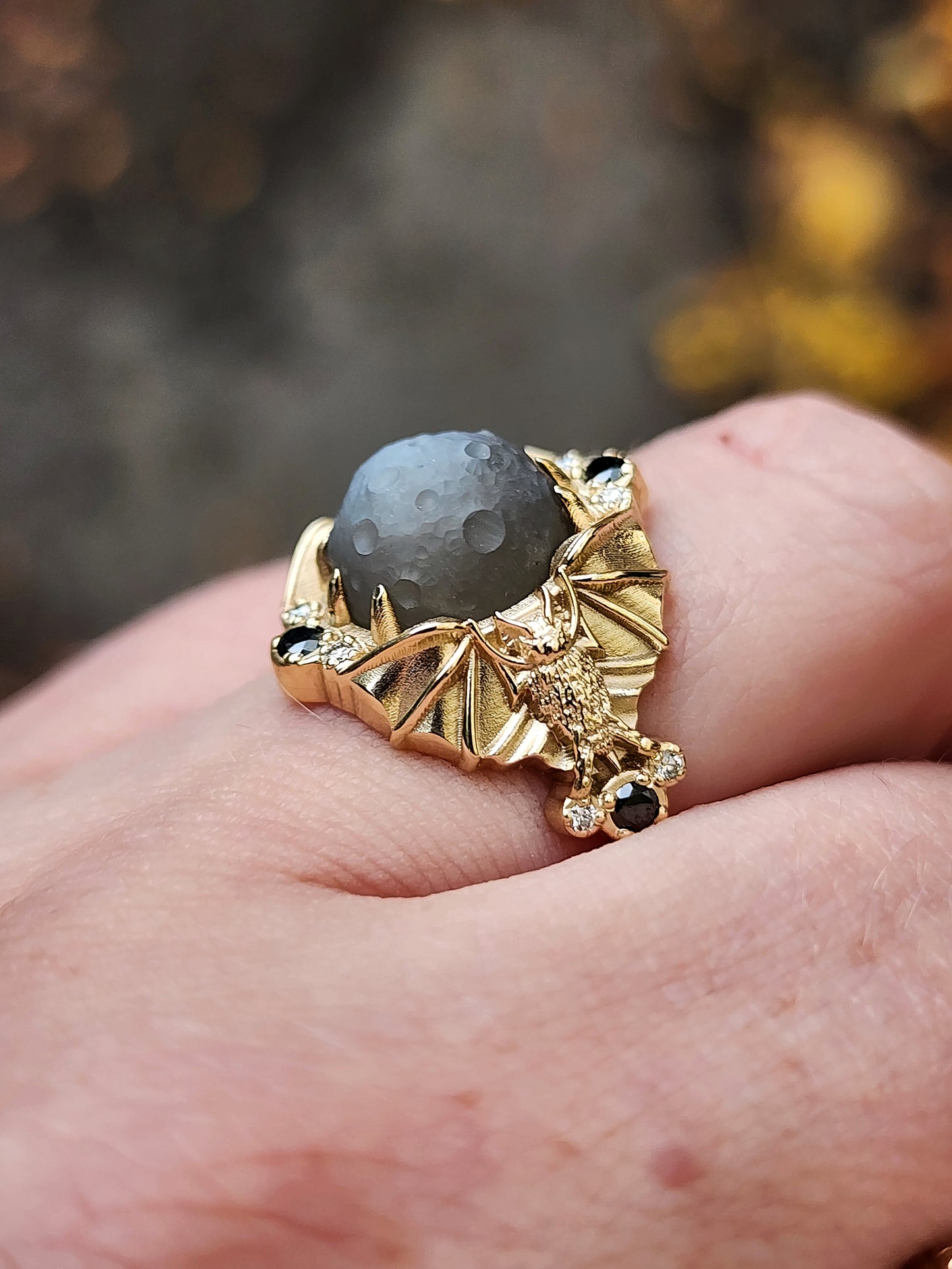 Keepers of the Moon ring by SwankMetalsmithing with hand carved gray moonstone moon and gold vampire bats