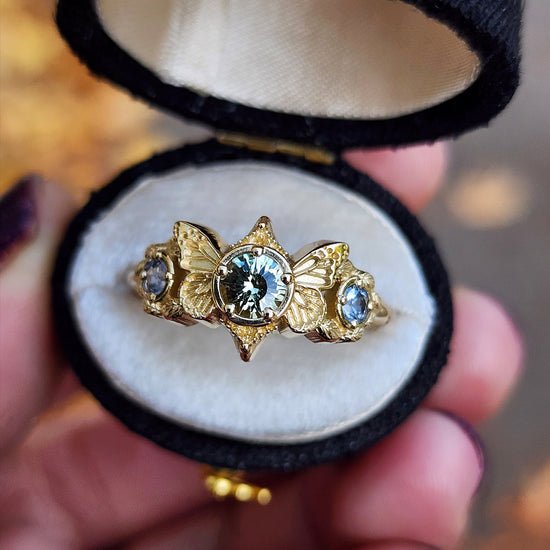 3 stone ring with Merelani mint garnet and blue sapphires with gold butterfly wings and leaves nature engagement anniversary gift