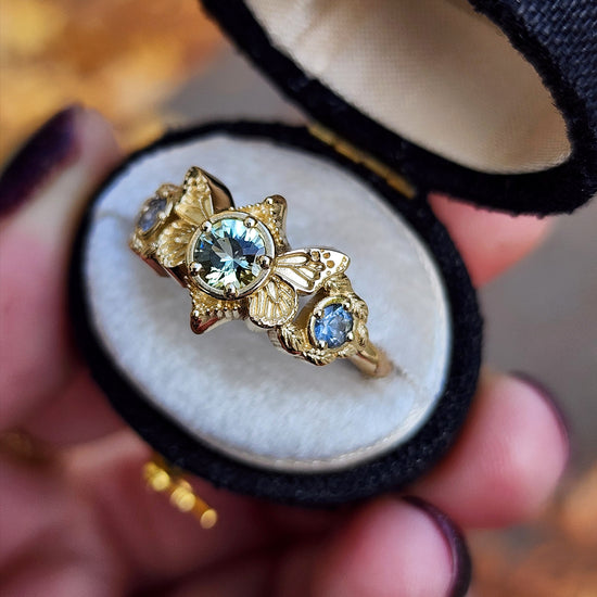 3 stone ring with Merelani mint garnet and blue sapphires with gold butterfly wings and leaves nature engagement anniversary gift