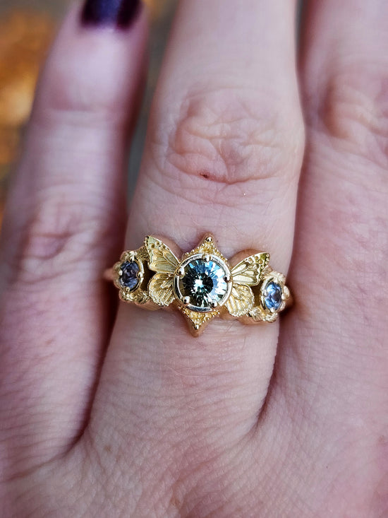 3 stone ring with Merelani mint garnet and blue sapphires with gold butterfly wings and leaves nature engagement anniversary gift