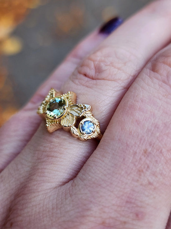 3 stone ring with Merelani mint garnet and blue sapphires with gold butterfly wings and leaves nature engagement anniversary gift