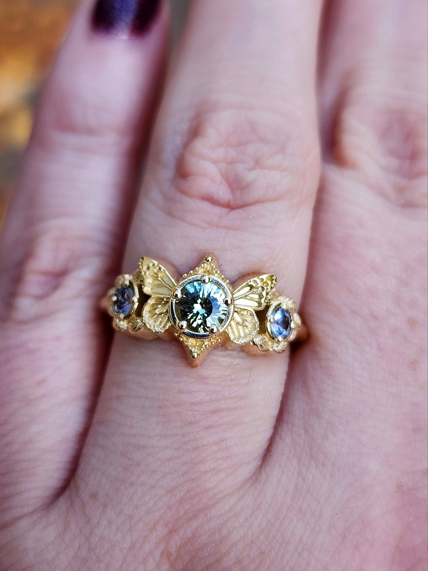 3 stone ring with Merelani mint garnet and blue sapphires with gold butterfly wings and leaves nature engagement anniversary gift